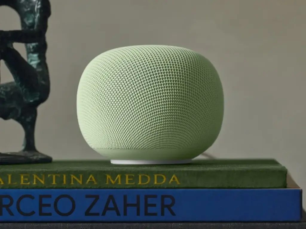 Google Home Speaker sitting on a shelf between books